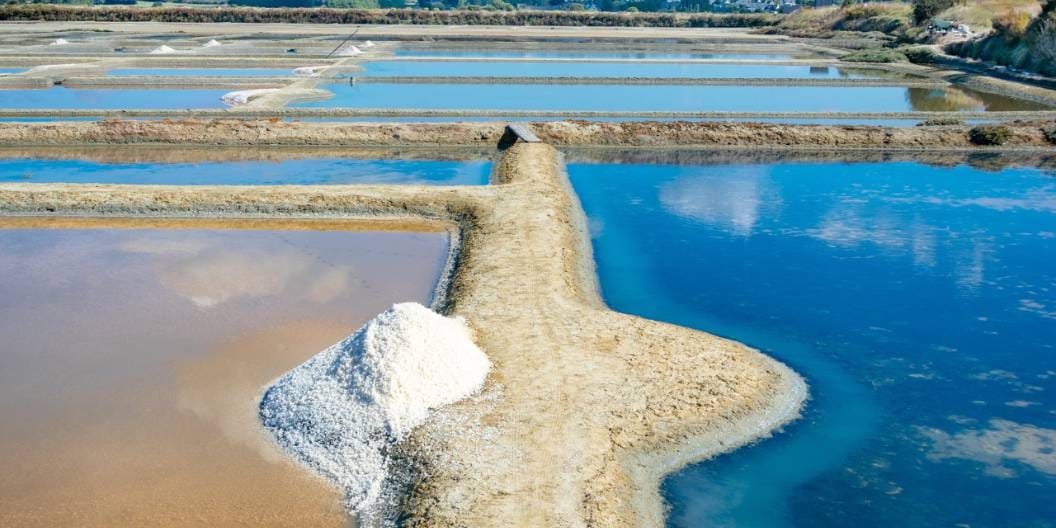塩田に盛られた天日塩ときれいな海水